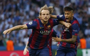 Barcelona's Ivan Rakitic, left, celebrates with Neymar after scoring his side's first goal during the Champions League final soccer match between Juventus Turin and FC Barcelona at the Olympic stadium in Berlin Saturday, June 6, 2015. (AP Photo/Luca Bruno)