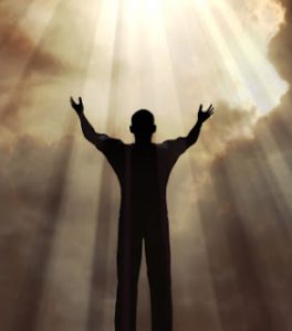 Man holding arms up in praise against a sunburst